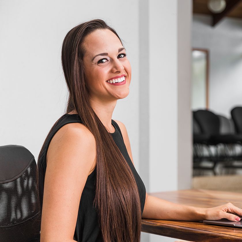 Clienta sonriendo frente a su laptop mientras cambia dólares en la plataforma de Money Plus